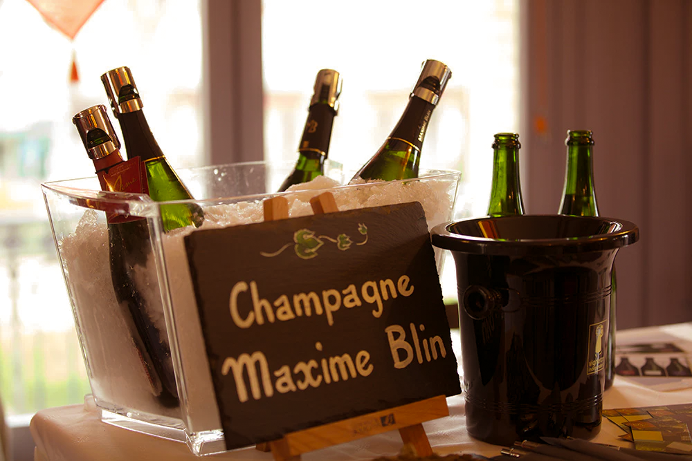 Bucket of ice with champagne bottles and a sign reading 'Champagne Maxime Blin'